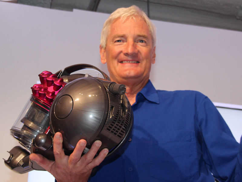 「DC46 モーターヘッド」を手に持つジェームズ ダイソン氏